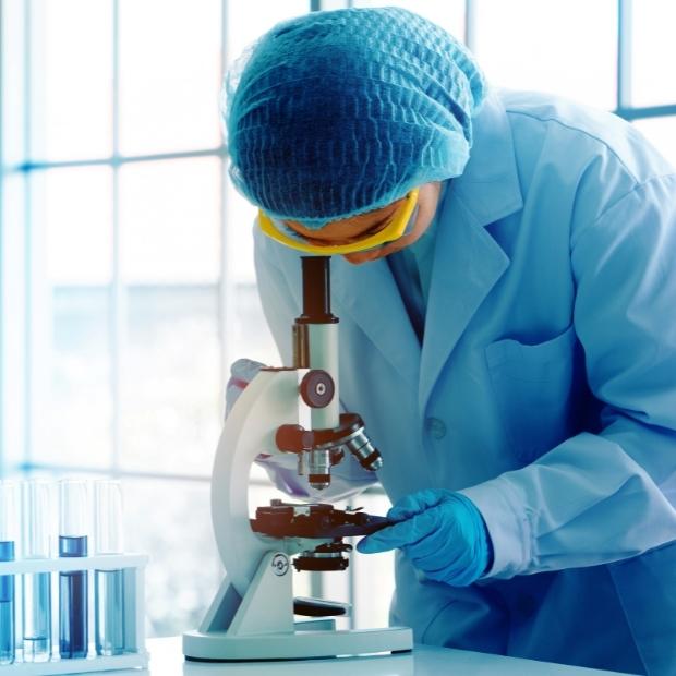 Investigador en el laboratorio mirando a través de un microscopio.