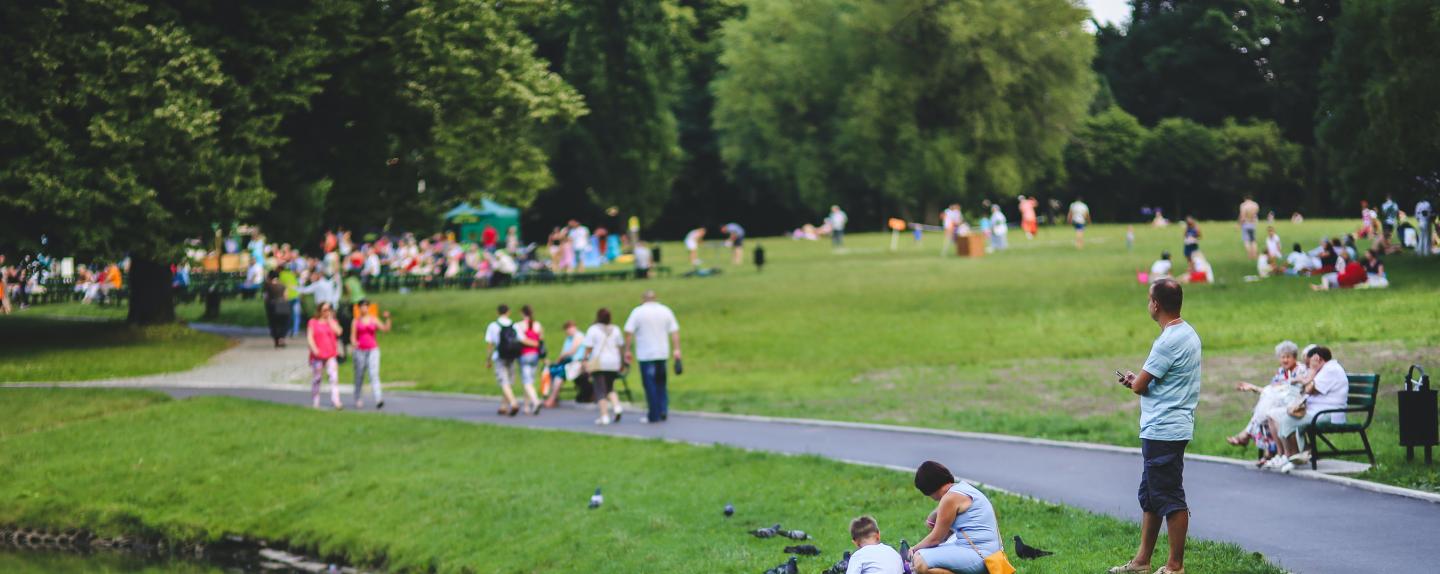 Photo of people sitting on the grass on a park.