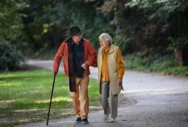 Older couple walking through a park