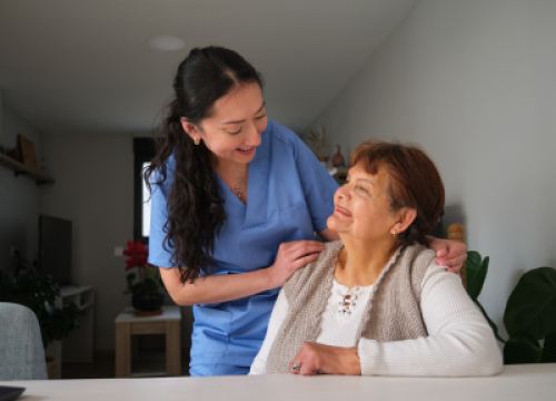 Hispanic caregiver taking care of older woman
