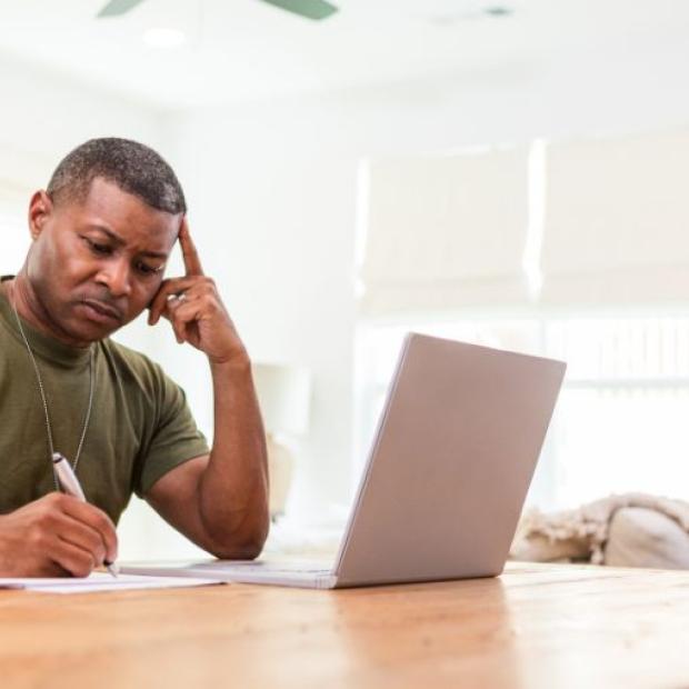Veteran on a laptop and writing notes