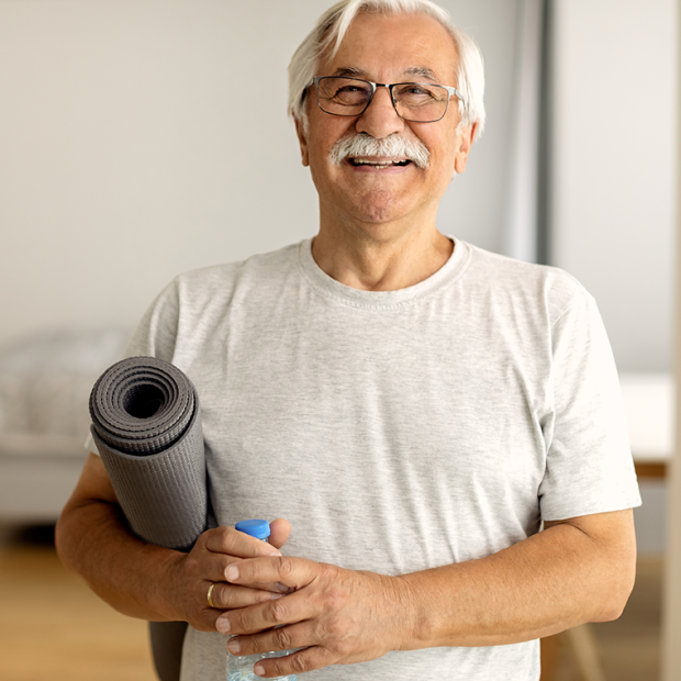 Man holding yoga mat and bottled water