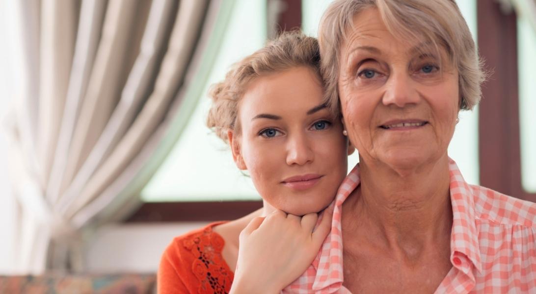 Adult daughter holding to senior mom's shoulder