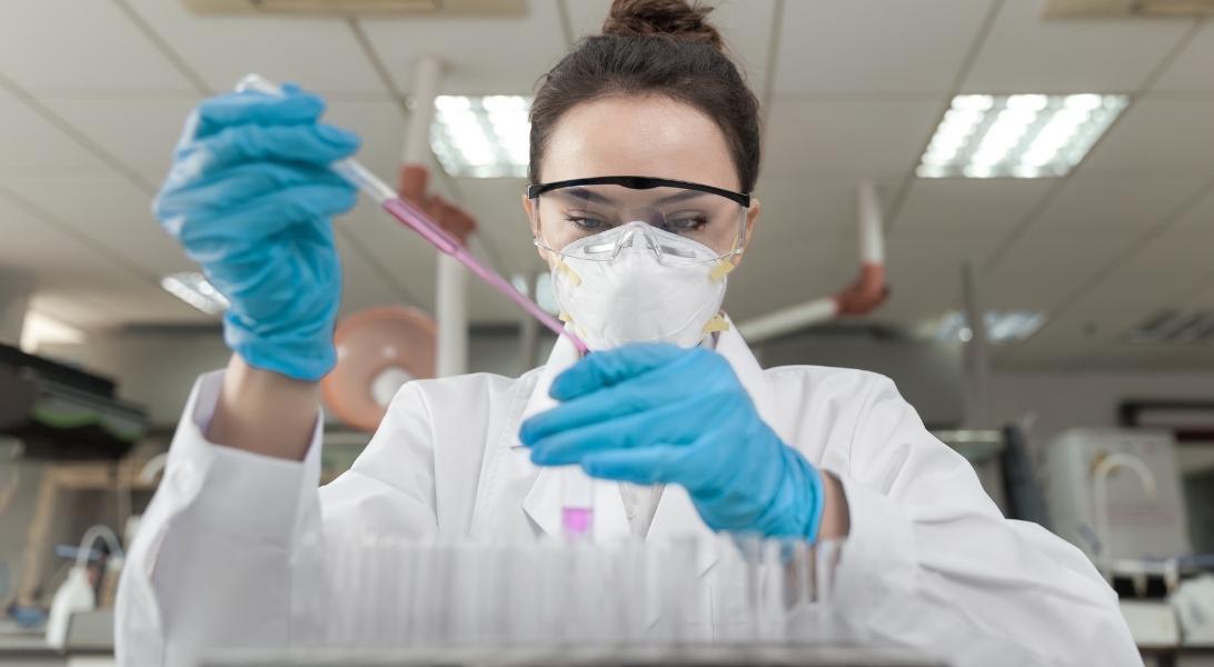 Researcher testing vials in lab