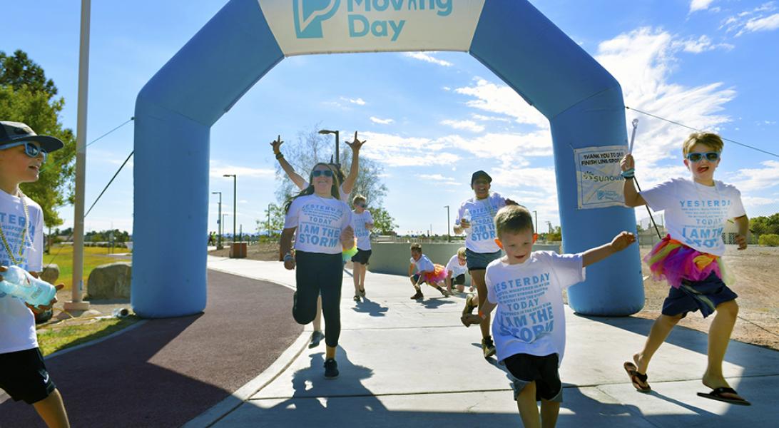 People running through the Moving Day walk's finish line.