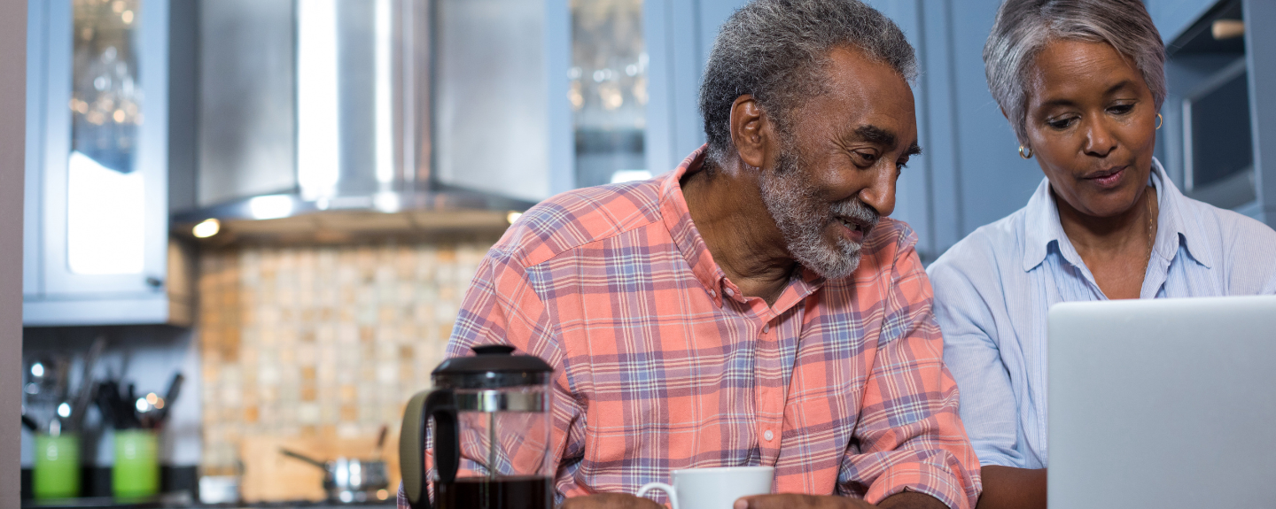 Couple looking at laptop drinking coffee