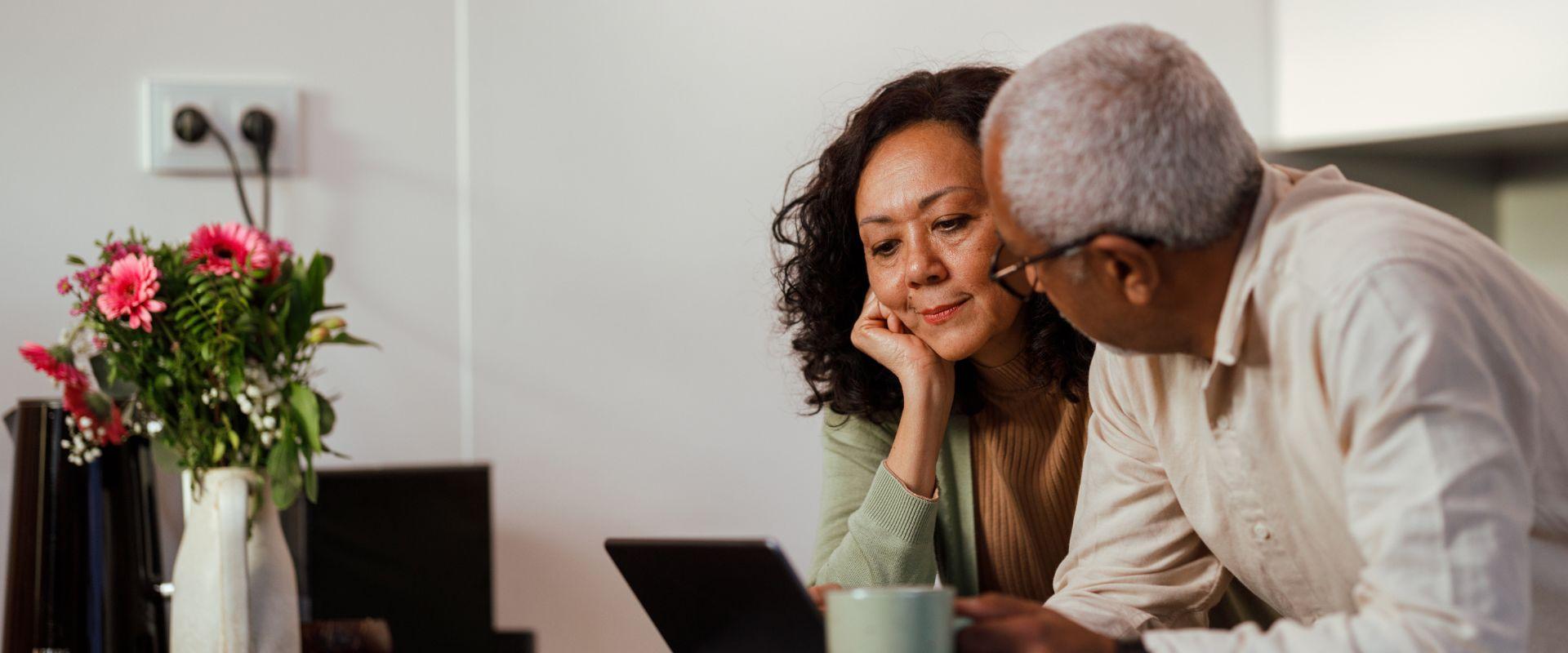 Couple looking at laptop in kitchen