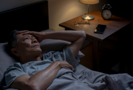 Man laying in bed having trouble sleeping