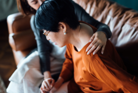 Woman helping elderly woman in pain