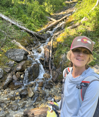 DawnElla Rust out in nature smiling at the camera.