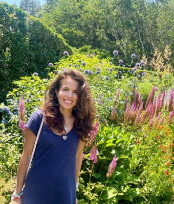 Karen Rosenbaum posing in front of a field of flowers