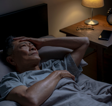 Man laying in bed having trouble sleeping