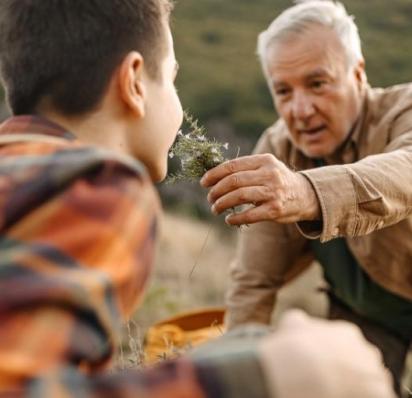 Man holding flower up to son's nose