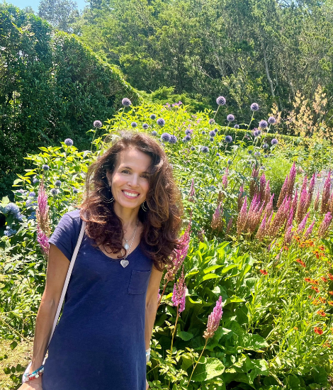 Karen Rosenbaum posing in front of a field of flowers