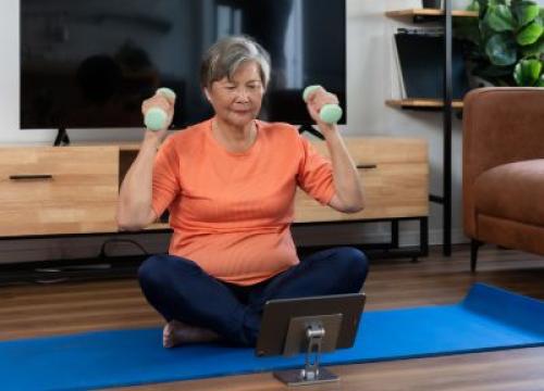 Woman exercising at home with tablet