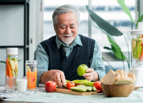 Man sitting at a table holding an apple