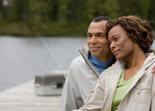 Couple sitting on a dock looking out on to the water