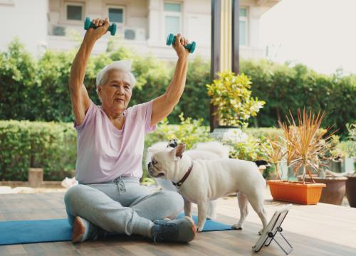 Woman working out outside with her dog.