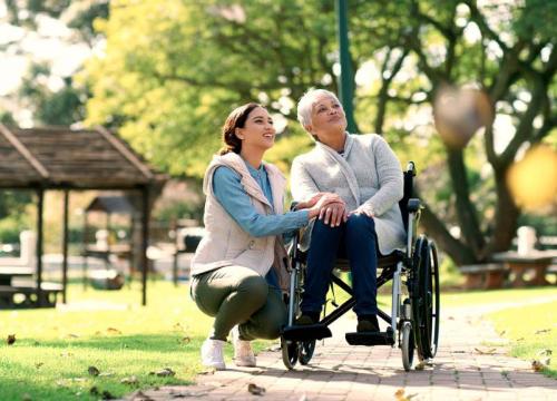 Woman in wheelchair with granddaughter outside on a walk