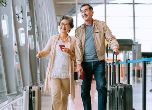 A couple walking through the airport with their bags