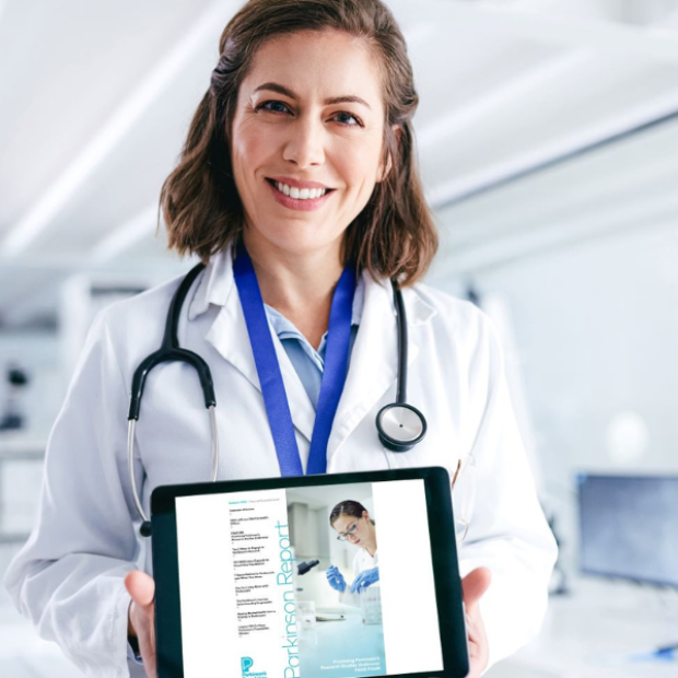 Female doctor holding a tablet displaying the Parkinson Report cover