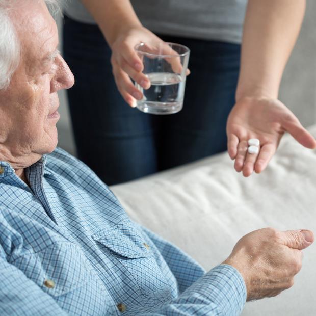 giving medications to older man