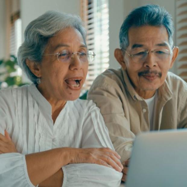 Asian couple engaging on laptop video call