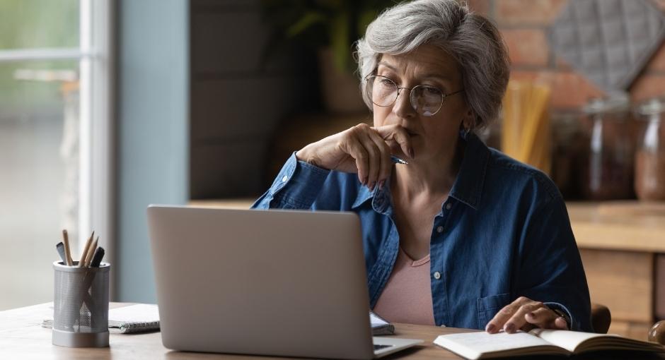 Woman on laptop taking notes while reading