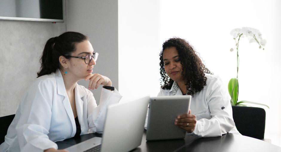 Two female researchers looking at a laptop and tablet