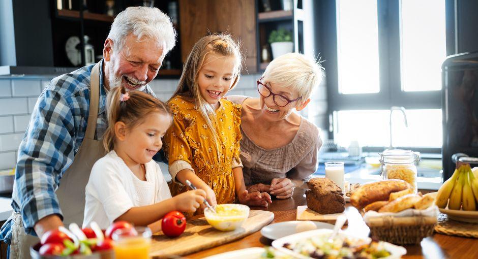 Grandparents with granddaughters cooking in kitchen