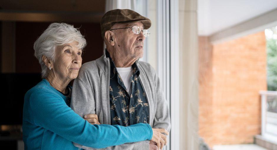 Wife hugging husband while looking out window