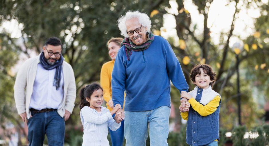Three generation Hispanic family taking walk in park
