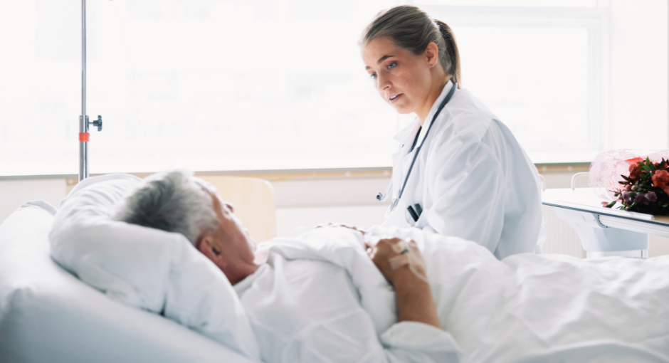 Female doctor talking to hospital patient in bed