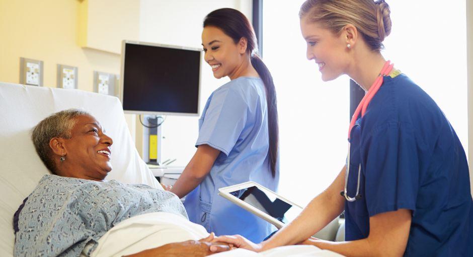 Two nurses taking care of patient in hospital