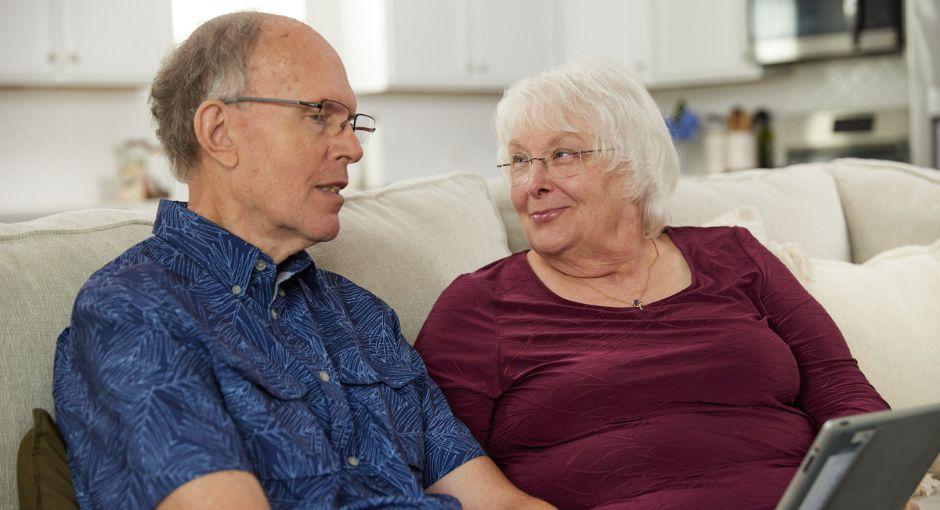 Couple sitting on the couch smiling at each other