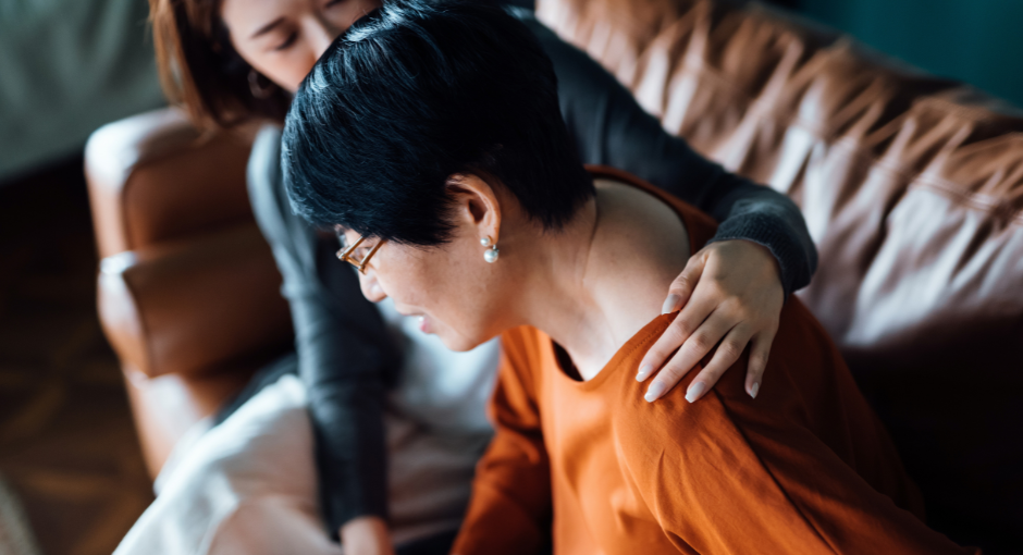 Woman helping elderly woman in pain