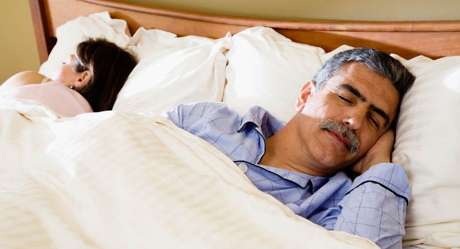 Husband and wife sleeping in bed