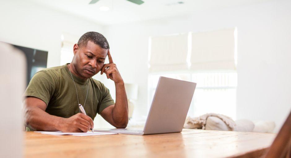 Veteran on a laptop and writing notes