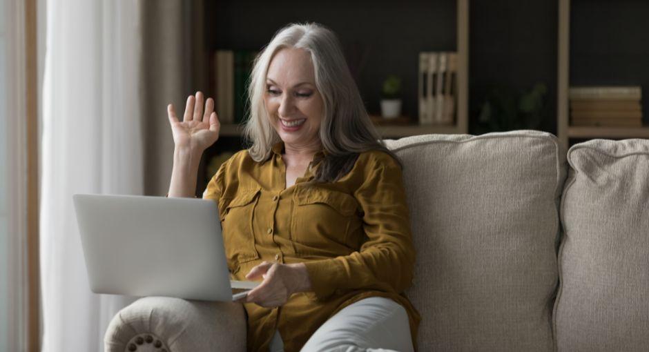 Woman on a call waving to her laptop