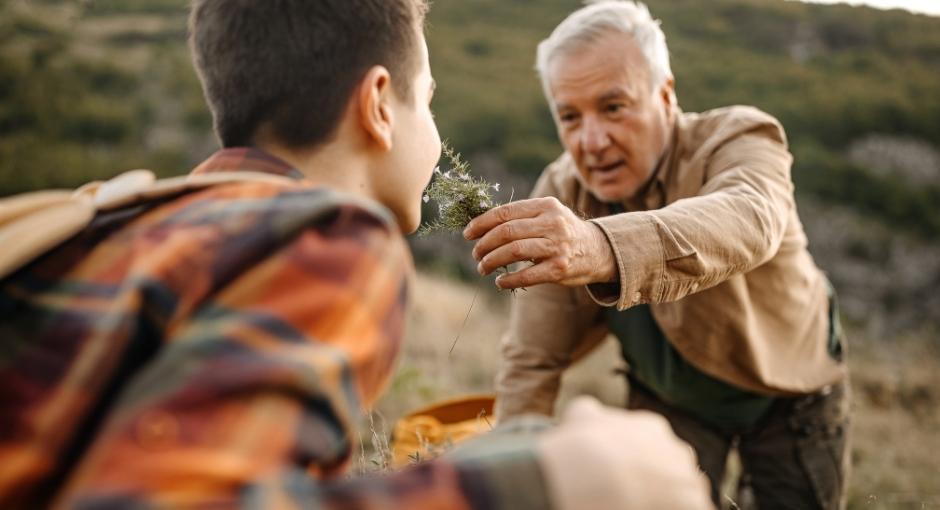 Man holding flower up to son's nose