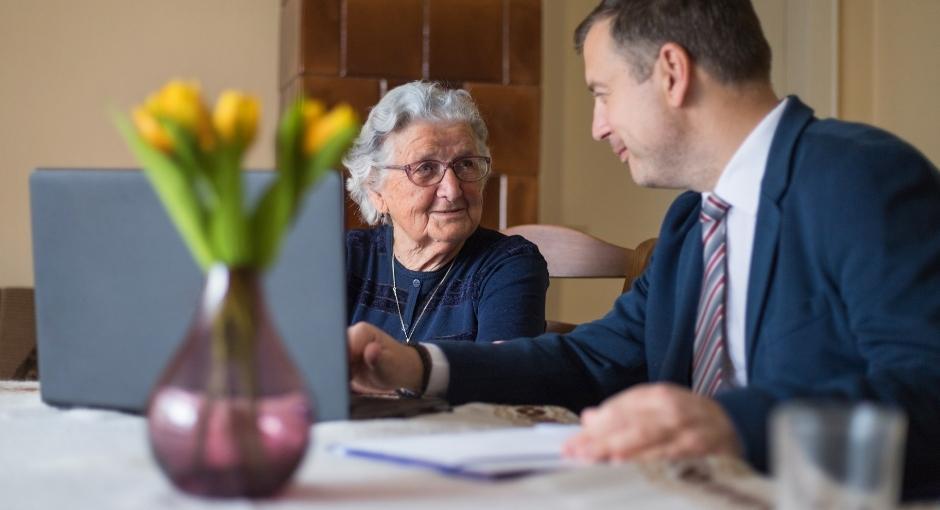 Man in suit helps woman with paperwork