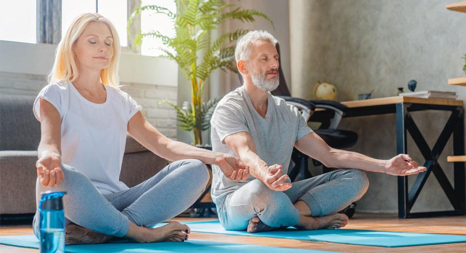 Mindfulness Monday banner - two people doing yoga in their living room