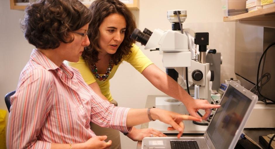 Two women studying research in lab