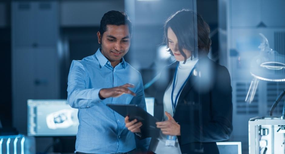 Two researchers looking at an IPad