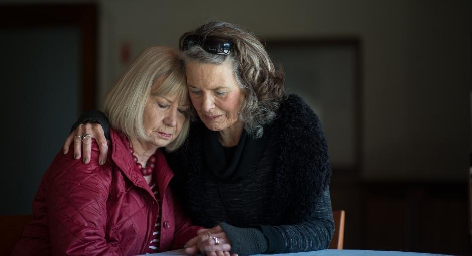 Woman comforting another woman with a hug