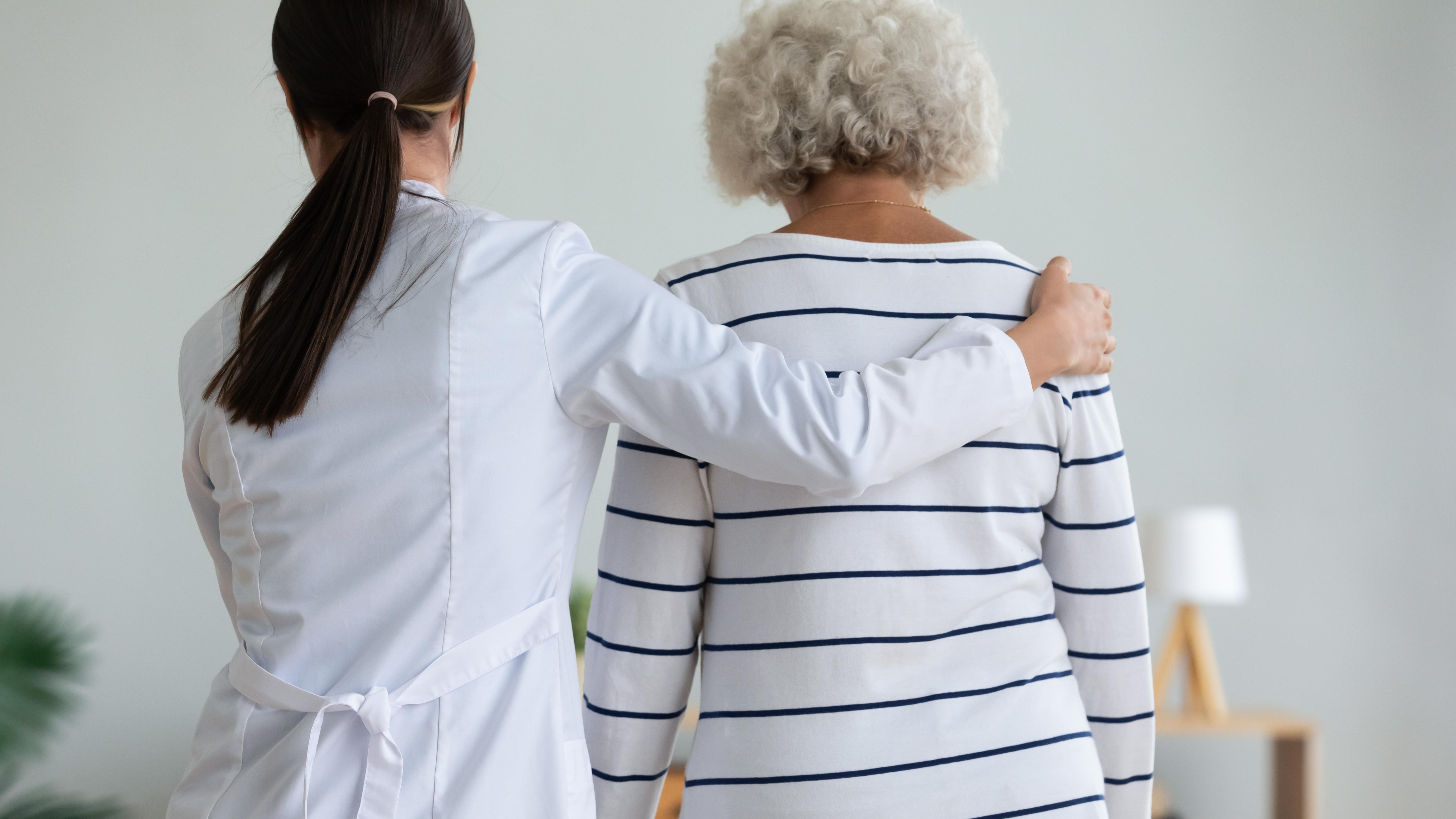 Doctor supporting an older woman