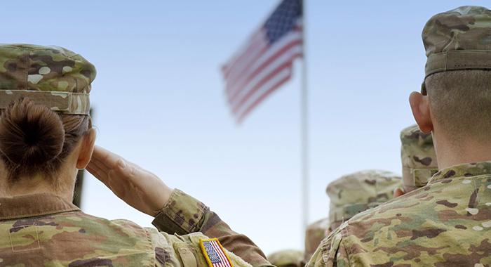 Photo of people in uniform saluting the American flag