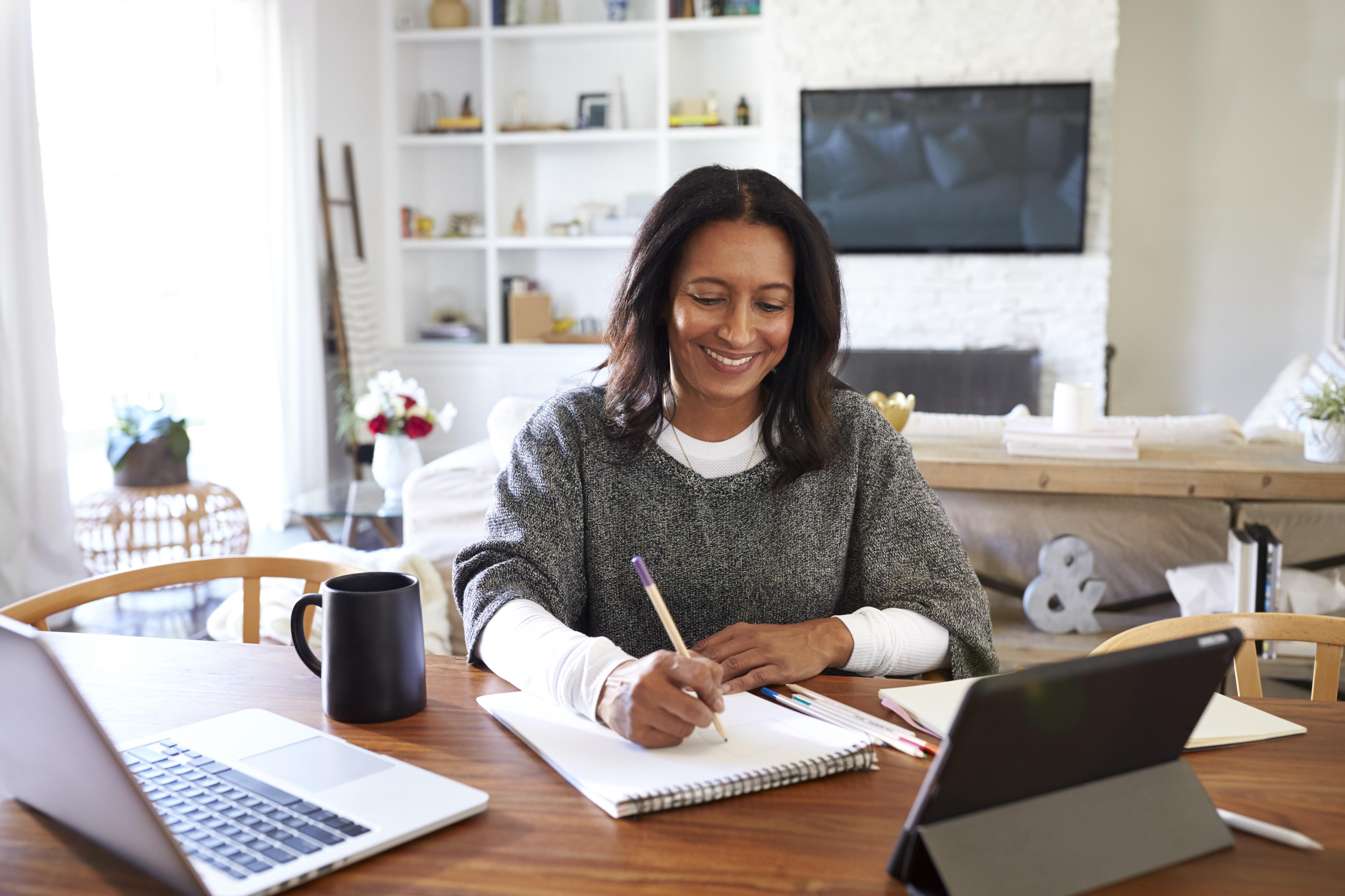 Woman writing notes at her desk